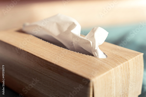 Beige paper tissue box detail with light wooden texture photo