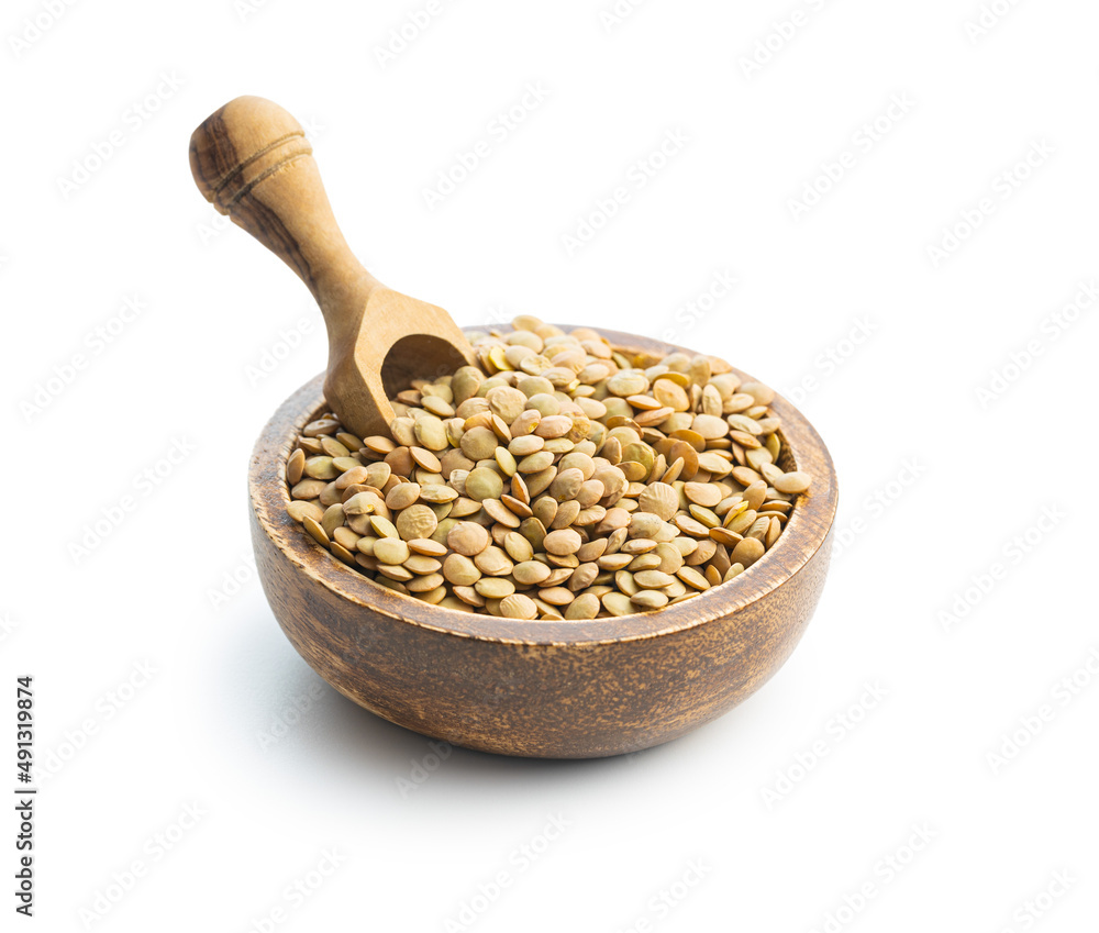 Uncooked brown lentils. Raw legume in wooden bowl isolated on white background. Uncooked brown lentils. Raw legume in wooden bowl isolated on white background.