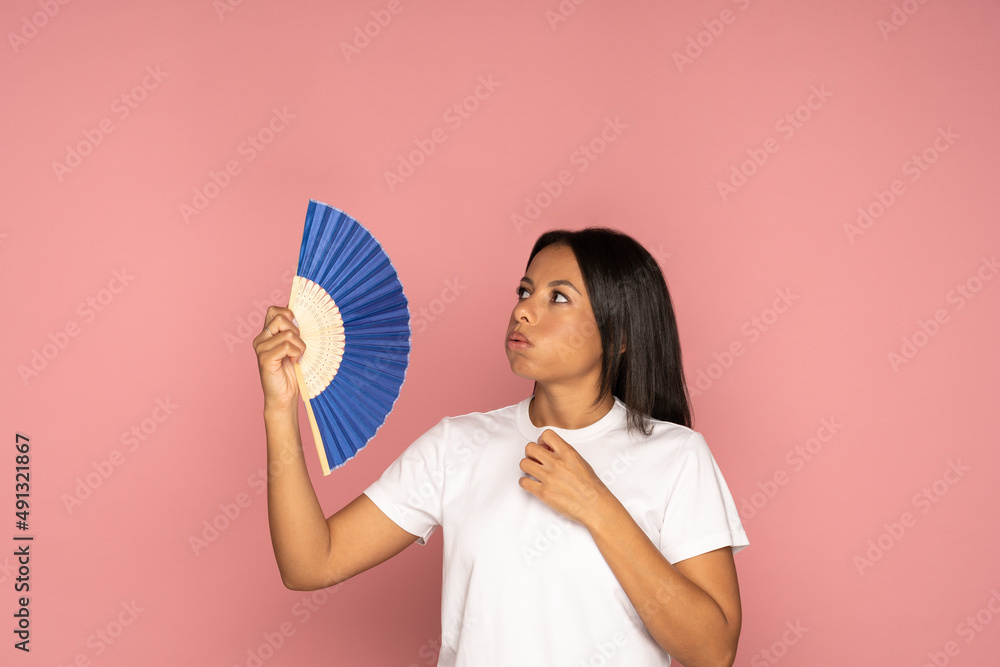 African american tired overheated woman using paper fan suffer from heat sweating, cools herself, feels sluggish due problem no air conditioner at home at summer weather, isolated on pink background African american tired overheated woman using paper fan suffer from heat sweating, cools herself, feels sluggish due problem no air conditioner at home at summer weather, isolated on pink background