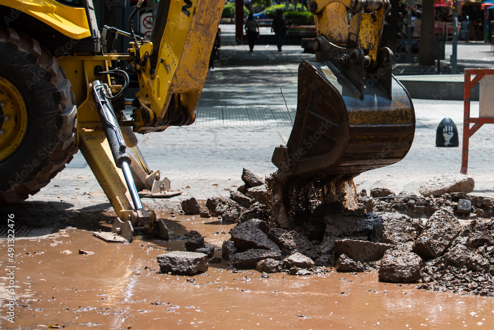 Fototapeta premium bulldozer shovel lifting debris strewn over the street