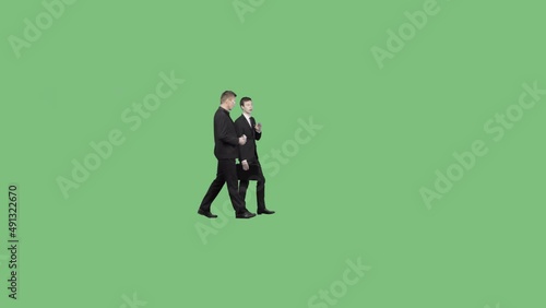 Two clerks in business clothes are walking and talking. Green screen video with alpha channel
