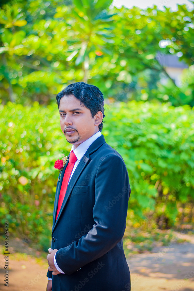 A handsome young man sitting with a green background A handsome young man sitting with a green background