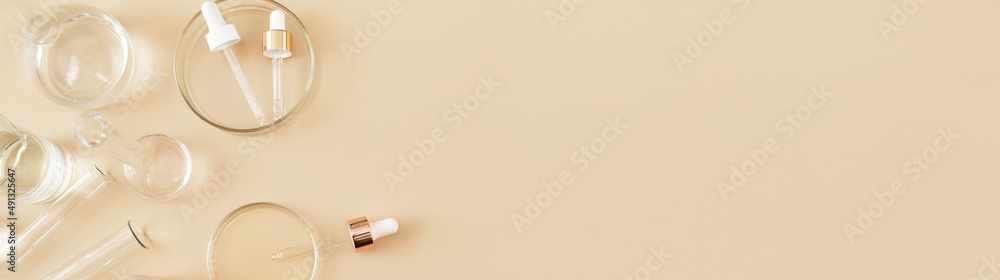 Banner made Laboratory glassware and pipette with serum and oil on beige background. Natural medicine, cosmetic research, bio science, organic skin care products. Concept skincare. Flat lay, top view. Banner made Laboratory glassware and pipette with serum and oil on beige background. Natural medicine, cosmetic research, bio science, organic skin care products. Concept skincare. Flat lay, top view.