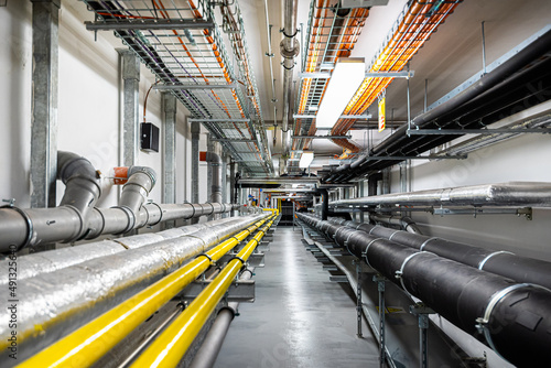 Gas and waste pipelines in the underground premises of the factory, industrial background, building utilities photo