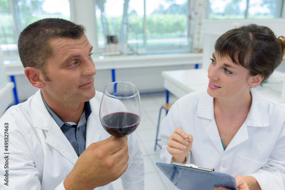 smiling cheerful positive male winemaker in lab coat