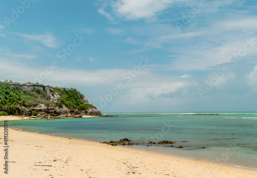 Praia com muitas pedras, cheias de musgo, areias escuras, na Praia dos Espelhos, Bahia que é um apelido devido ao efeito causado pelo reflexo do sol nas piscinas naturais quando avistadas do mar.