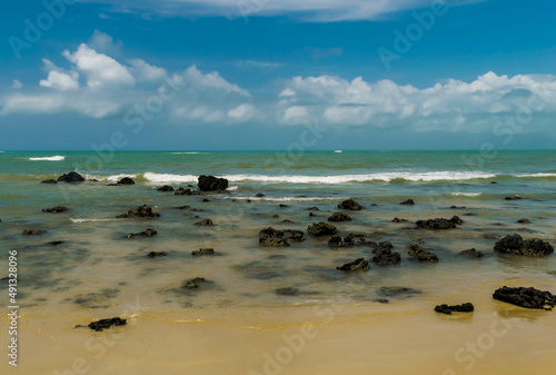 Linda praia com muitas pedras na areia localizada na Praia dos Espelhos, Bahia, chamada assim devido ao efeito causado pelo reflexo do sol nas piscinas naturais quando avistadas do mar.
