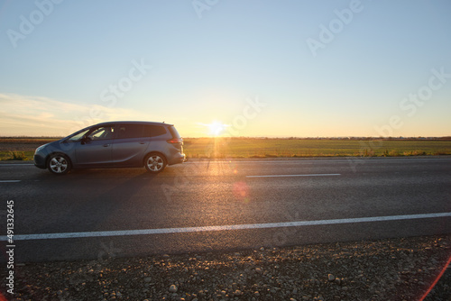 Car driving fast on intercity road at sunset. Highway traffic in evening