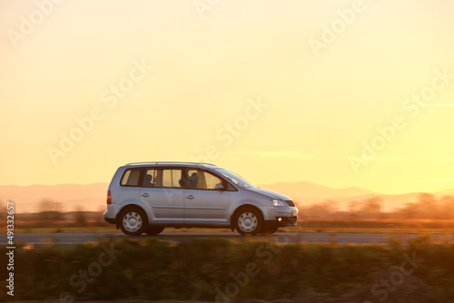 Fototapeta Naklejka Na Ścianę i Meble -  Car driving fast on intercity road at sunset. Highway traffic in evening