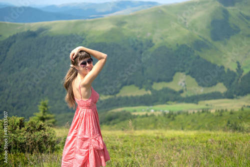 Wallpaper Mural Young woman in red dress standing on grassy field on a windy day in summer mountains enjoying view of nature Torontodigital.ca