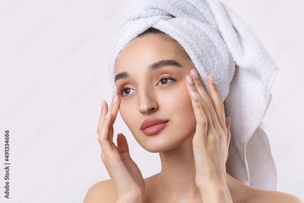 Beautiful girl with thick eyebrows and perfect skin at white background, towel on head, beauty photo. Beautiful girl with thick eyebrows and perfect skin at white background, towel on head, beauty photo.