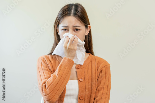 Sick, Coronavirus covid asian young woman, girl have a fever, flu, hand in use tissues paper sneezing nose, runny and cough, standing on isolated background. Health care to disease influenza seasonal