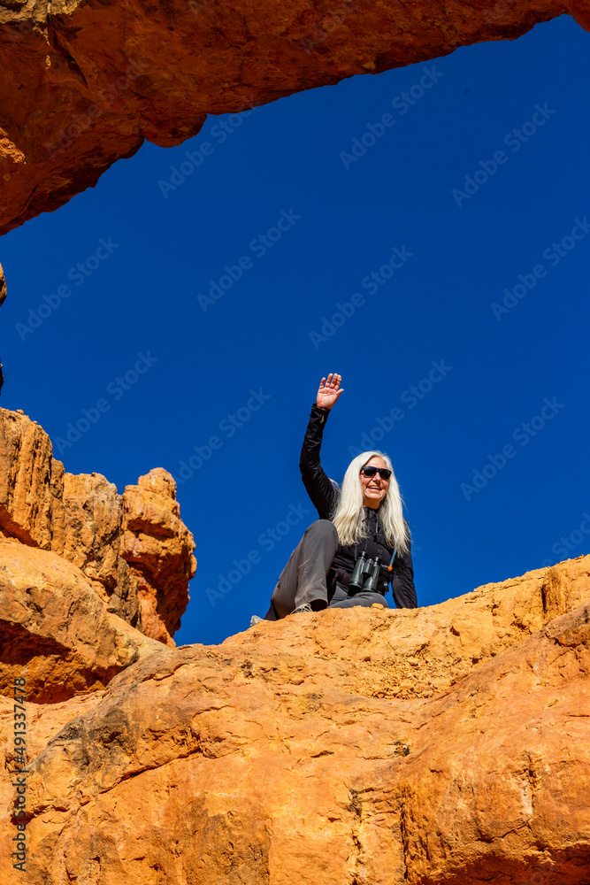United States, Utah, Escalante, Senior hiker sitting on sandstone ledge United States, Utah, Escalante, Senior hiker sitting on sandstone ledge