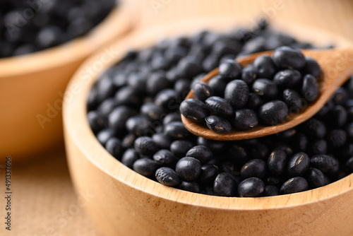 Black soybean seeds in wooden spoon and bowl, Food ingredients