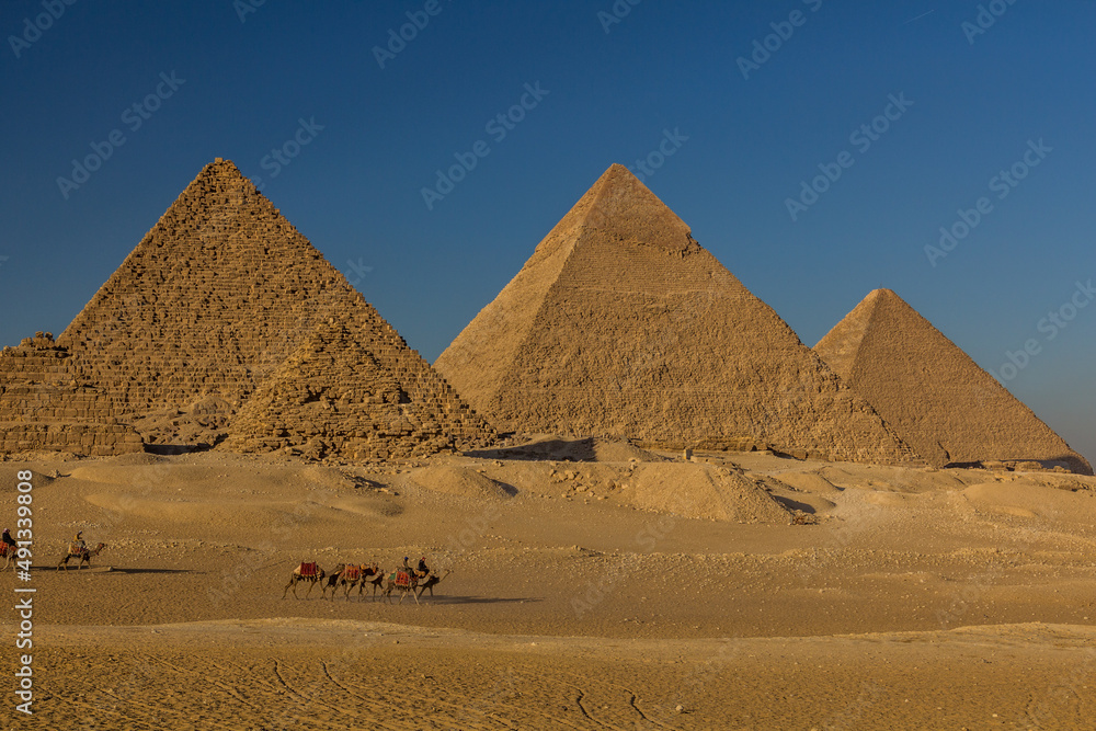 CAIRO, EGYPT - JANUARY 28, 2019: Camel riders in front of the Great pyramids of Giza, Egypt