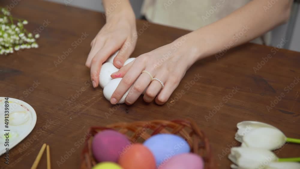 Close-up on a table with items to create a composition for Easter. Women's hands put Easter eggs on the table. Church holiday-Easter Close-up on a table with items to create a composition for Easter. Women's hands put Easter eggs on the table. Church holiday-Easter