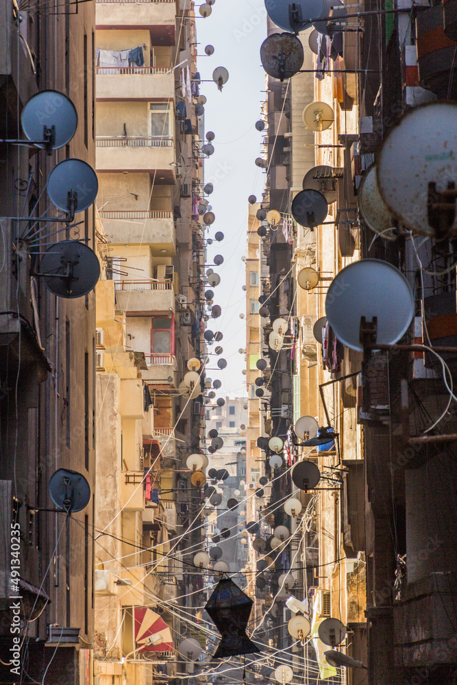 Narrow alley with satellite dishes in Alexandria, Egypt Narrow alley with satellite dishes in Alexandria, Egypt