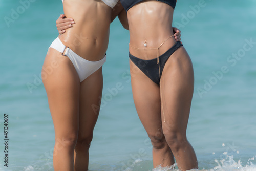 woman in bikini. woman in bikini. Sexy bikini with drops of water of a young beautiful sporty woman in bikini posing on the beach after swimming on sunny summer day. Photo of a girl's butt in a white 