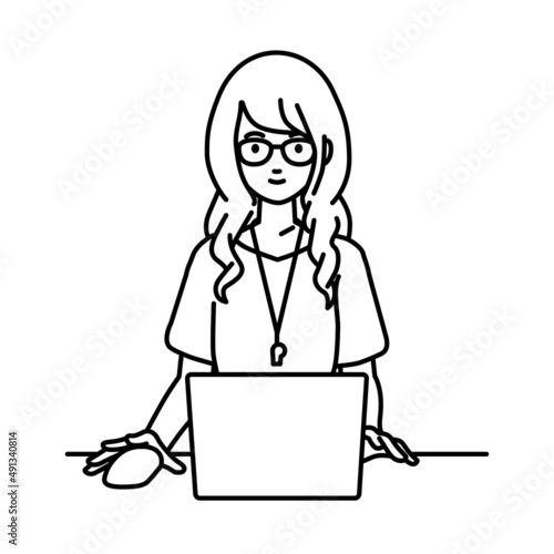 デスクで座ってPCを使っている教師の女性