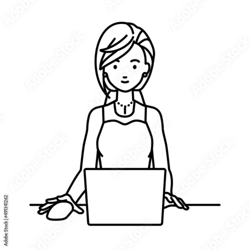 デスクで座ってPCを使っているドレスの女性