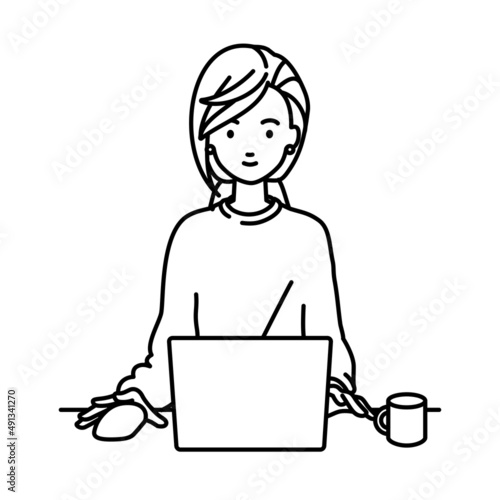 デスクで座ってPCを使っているリモートワークの女性