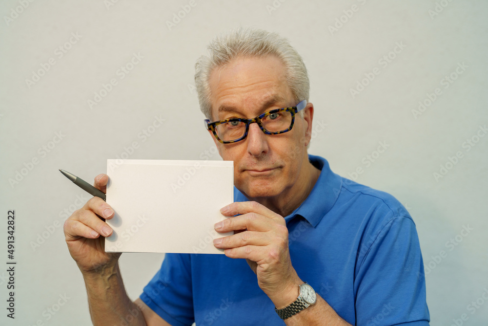 Old man holding a blank postcard Old man holding a blank postcard