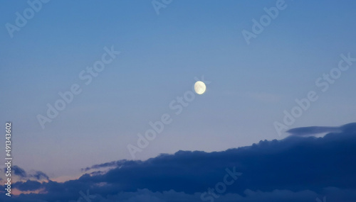 Mezza Luna del pomeriggio sopra le nuvole