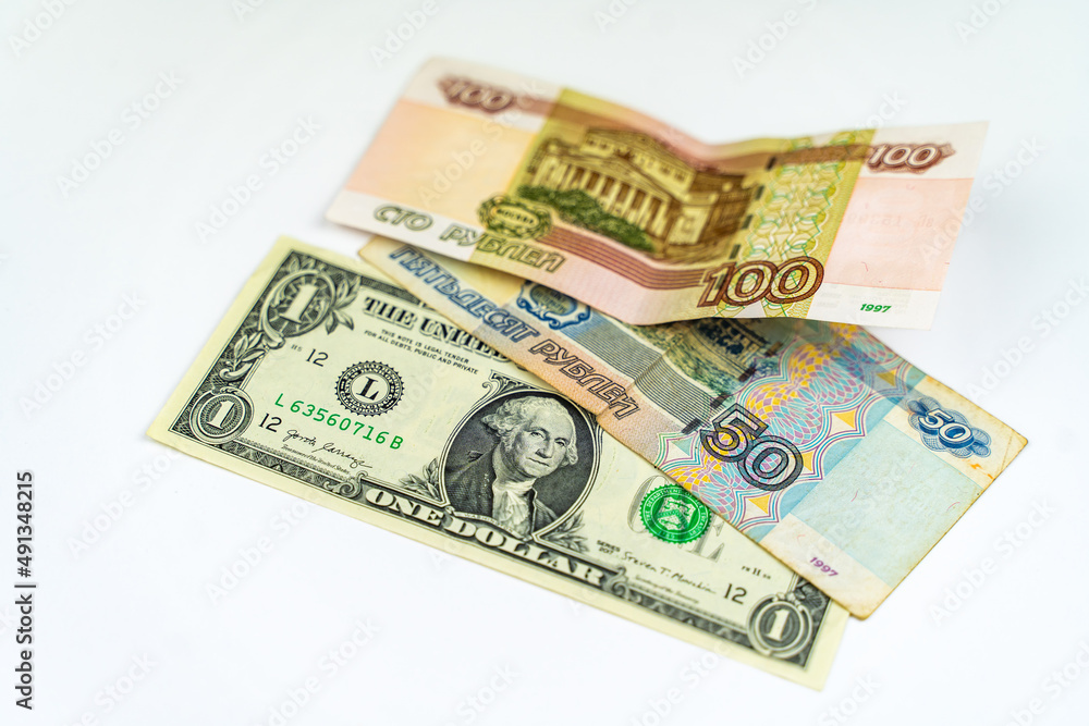 One American dollar and one hundred fifty Russian rubles on a white background. Russian ruble and US dollar exchange rate. One American dollar and one hundred fifty Russian rubles on a white background. Russian ruble and US dollar exchange rate.