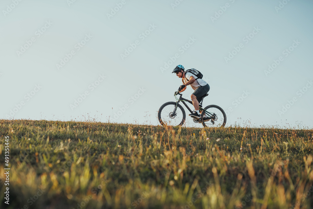 Obraz premium Cyclist Riding the Bike on the Trail in the Forest. Man cycling on enduro trail track. Sport fitness motivation and inspiration. Extreme Sport Concept. Selective focus