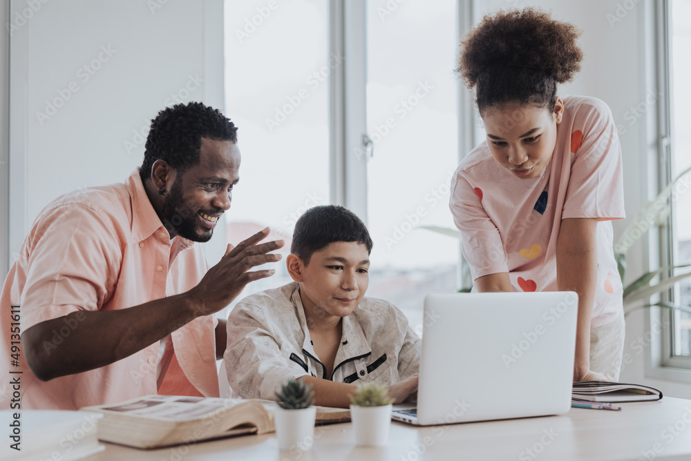 Asian boy learning online class from home with family. little boy sit with sister and dad using laptop learning online education from home. Education and E-learning concept.