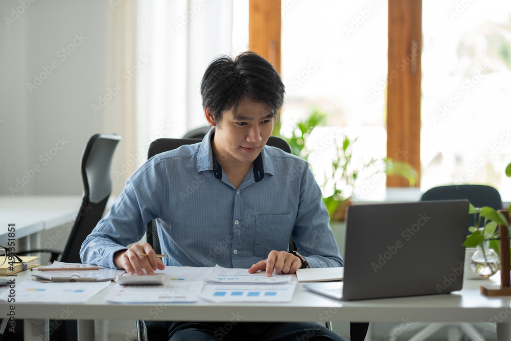 Businessman using calculator for do math finance on wooden desk in office and business working background, tax, accounting, statistics and analytic research concept Businessman using calculator for do math finance on wooden desk in office and business working background, tax, accounting, statistics and analytic research concept