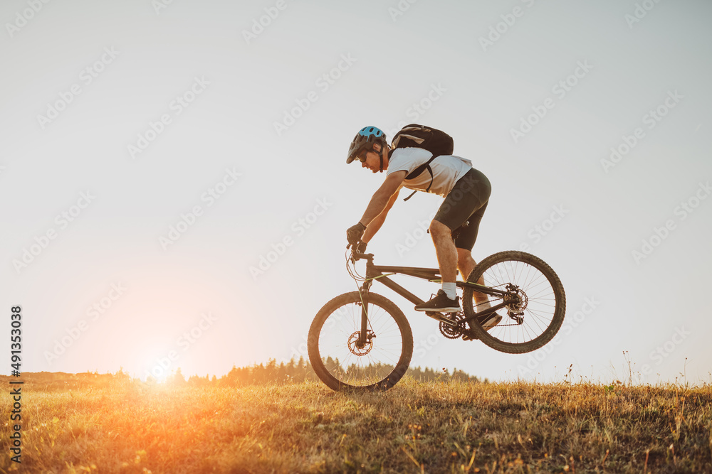 Naklejka premium Cyclist Riding the Bike on the Trail in the Forest. Man cycling on enduro trail track. Sport fitness motivation and inspiration. Extreme Sport Concept. Selective focus