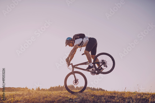 Fototapeta Naklejka Na Ścianę i Meble -  Cyclist Riding the Bike on the Trail in the Forest. Man cycling on enduro trail track. Sport fitness motivation and inspiration. Extreme Sport Concept. Selective focus