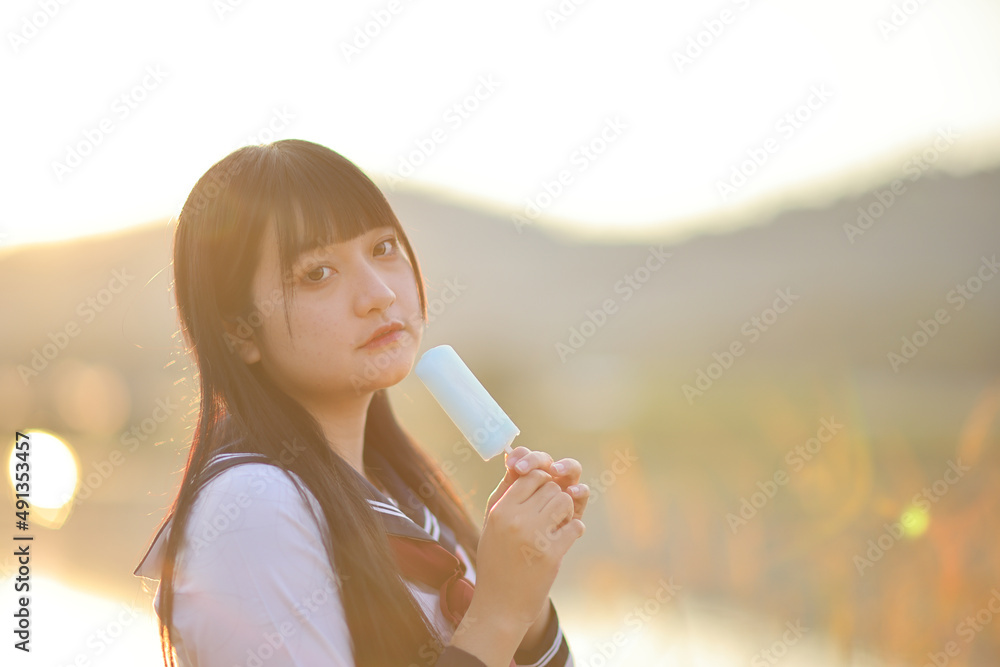Asian High School Girls student eating ice cream in countryside with sunrise Asian High School Girls student eating ice cream in countryside with sunrise