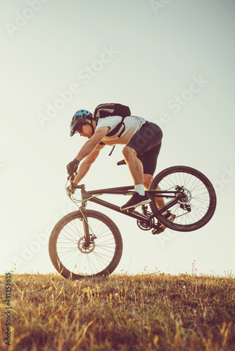 Fototapeta Naklejka Na Ścianę i Meble -  Cyclist Riding the Bike on the Trail in the Forest. Man cycling on enduro trail track. Sport fitness motivation and inspiration. Extreme Sport Concept. Selective focus