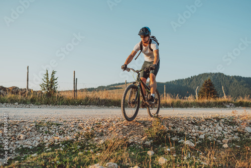 Cyclist Riding the Bike on the Trail in the Forest. Man cycling on enduro trail track. Sport fitness motivation and inspiration. Extreme Sport Concept. Selective focus © Minet