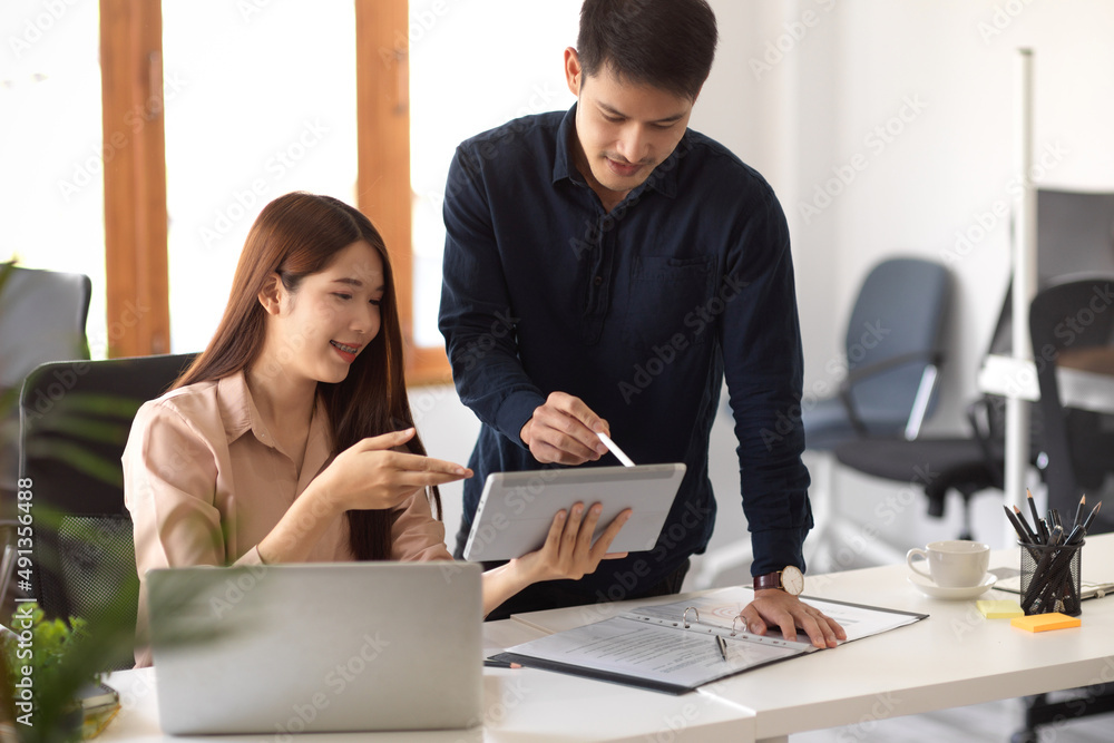 Two business coworker looking the details at tablet screen Two business coworker looking the details at tablet screen