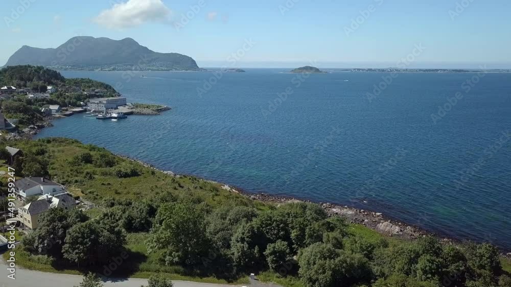 The western costal part of Alesund, Norway's most beautiful town is revealed in this forward flying drone footage. It is midday on a sunny summer day. The open sea and distant islands are visible too. The western costal part of Alesund, Norway's most beautiful town is revealed in this forward flying drone footage. It is midday on a sunny summer day. The open sea and distant islands are visible too.
