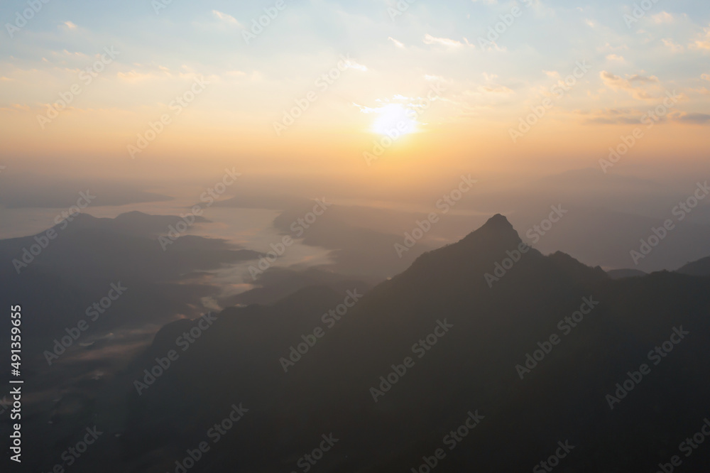 Aerial top view of forest trees and green mountain hills with fog, mist and clouds. Nature landscape background, Thailand. Aerial top view of forest trees and green mountain hills with fog, mist and clouds. Nature landscape background, Thailand.