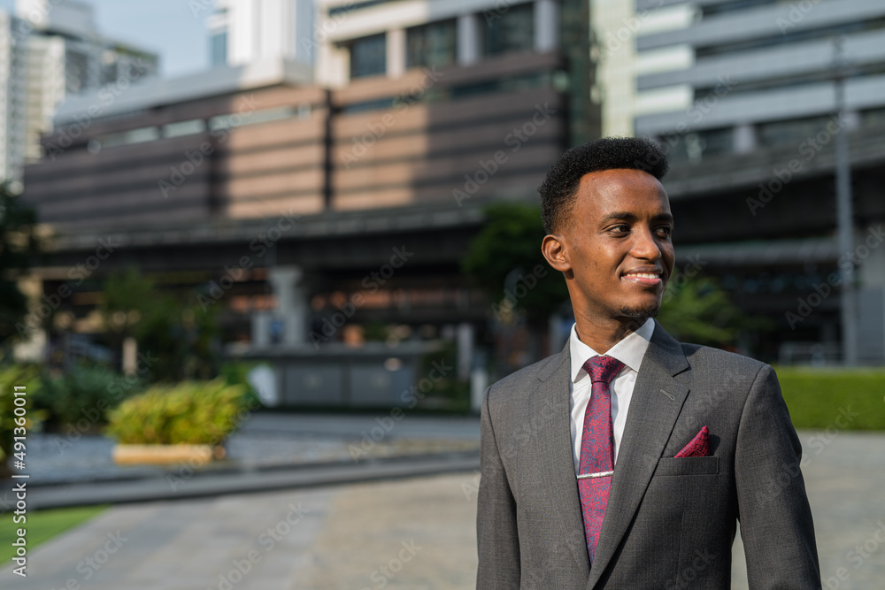 Portrait of handsome young African businessman thinking outdoors Portrait of handsome young African businessman thinking outdoors