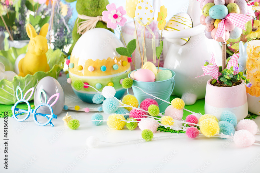 Fototapeta premium Easter time. Easter decorations on the rustic wooden table. Easter bunny, easter eggs in basket and cabbage leaf. Blue background.