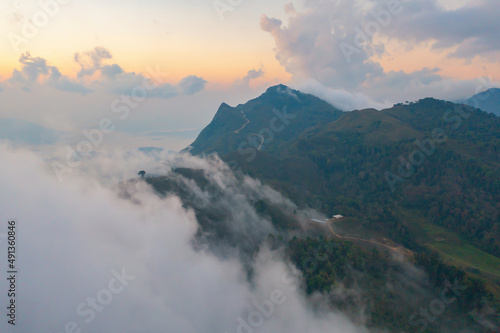 Aerial top view of forest trees and green mountain hills with fog, mist and clouds. Nature landscape background, Thailand. © tampatra