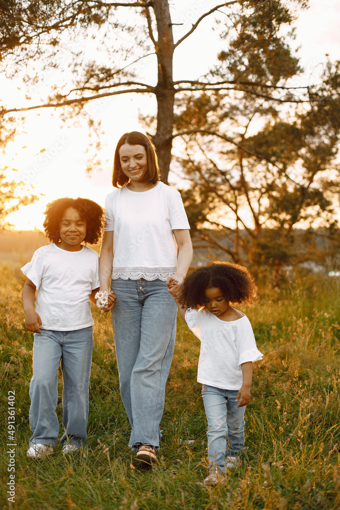 Caucasian mother and two her mixed race daughters walking in a park Caucasian mother and two her mixed race daughters walking in a park