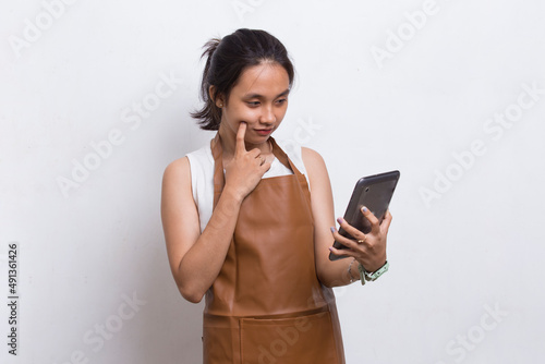 Happy joyful young Asian woman bartender or waitress using mobile smartphone isolated on white background 