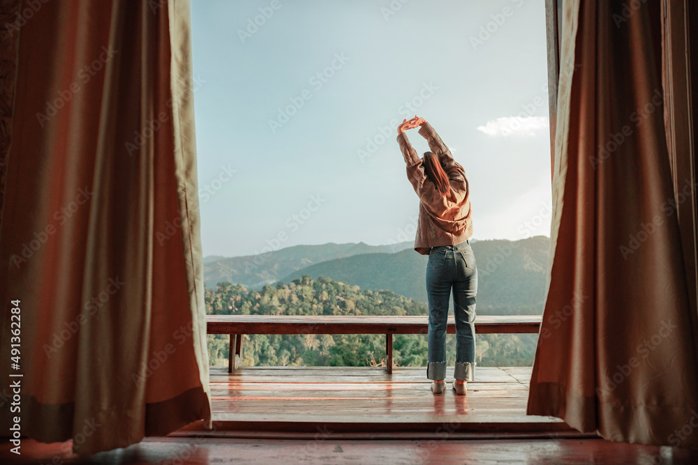 © oatawa - Woman relaxing on balcony which can see the mountain view and morning fog, Happy traveller stay in hotel.