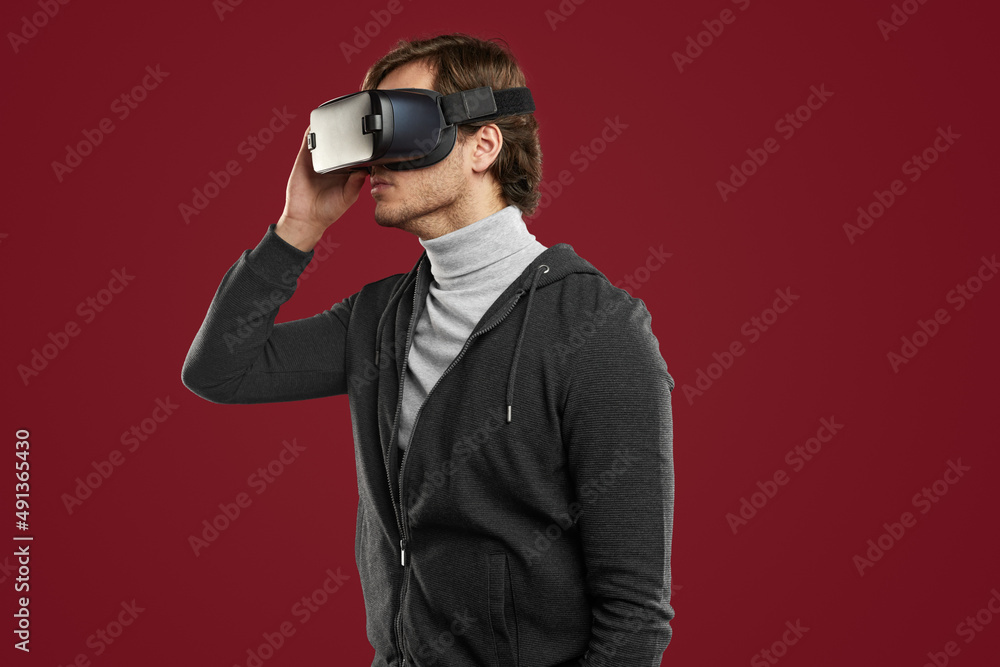 Calm man exploring virtual world in VR glasses Calm man exploring virtual world in VR glasses