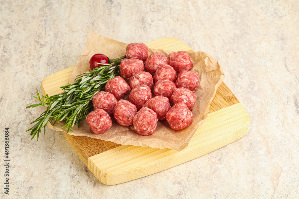 Raw uncooked beef meatballs served rosemary Raw uncooked beef meatballs served rosemary