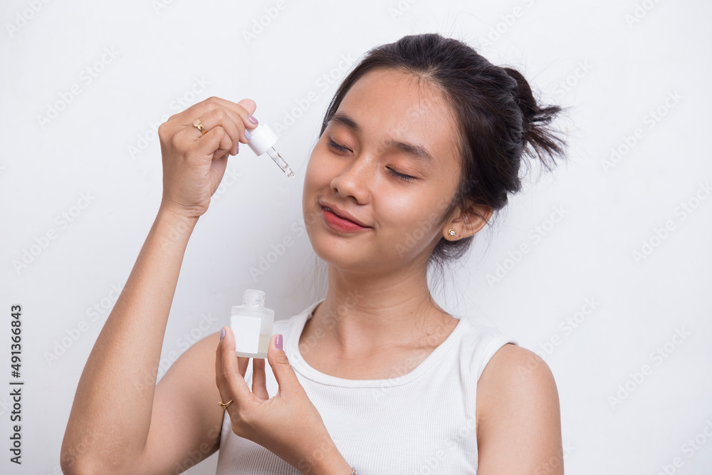 young beautiful asian woman putting moisturizing serum to her face isolated on white background
young beautiful asian woman putting moisturizing serum to her face isolated on white background