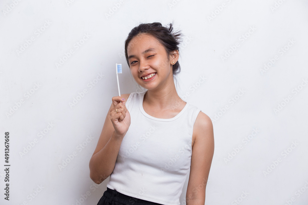 Young beautiful asian woman brushing her teeth isolated on white background
Young beautiful asian woman brushing her teeth isolated on white background