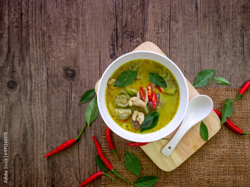 Top view of green curry chicken in white bow on wooden table with copy space